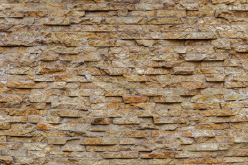 Textures. The wall is lined with natural sandstone. The facade of the house is lined with natural stone. Texture of natural stone on the wall
