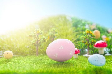 Colorful easter eggs and one big pink easter egg on spring green grass