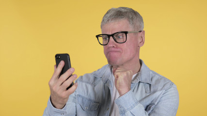 Shocked Old Man Using Smartphone, Yellow Background