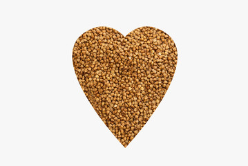 Buckwheat groats are laid out on a white background in the form of a heart. Favorite groats in Russia.