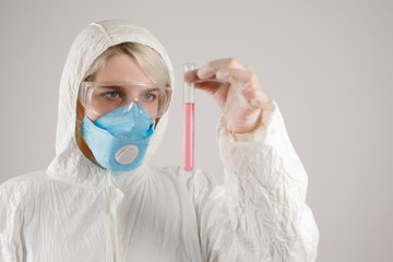 A girl in a protective suit and a respirator to protect health from viral, epidemic and infectious diseases. New Covid-19. Vaccine search concept. Stop the virus. Close-up.