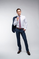 Young, handsome man in a blue suit in a white shirt with a tie on a white background in studio