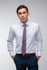 Young, handsome man in a white shirt with a tie on a white background in studio