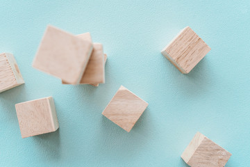 Wooden cubic on plastel color background.