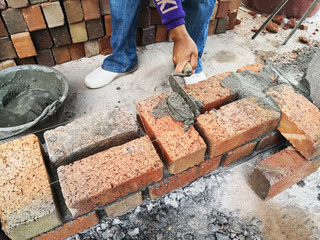 construction worker laying bricks at constrction site.
