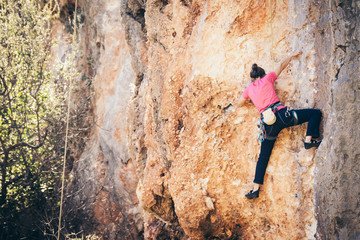 Girl climbs a rock.