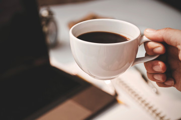 cup of coffee with hand on black background