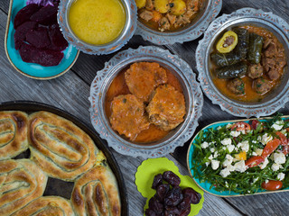 Eid Mubarak Traditional Ramadan Iftar dinner. Assorted tasty food in authentic rustic dishes on wooden table background.