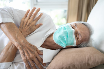 Sick senior woman wear a mask has a fever,shivering,high temperature,chilly,old people have a...