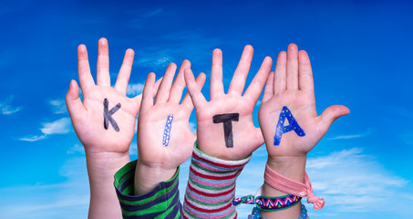 Children Hands Building Colorful German Word KITA Means Kindergarden. Blue Sky As Background - obrazy, fototapety, plakaty