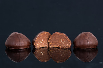 Three chocolate semicircular candies on a dark background