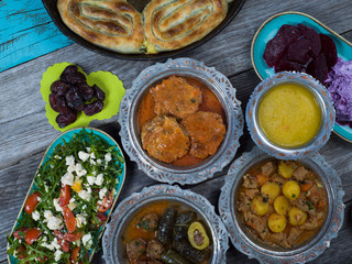 Eid Mubarak Traditional Ramadan Iftar dinner. Assorted tasty food in authentic rustic dishes on wooden table background.