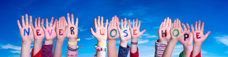 Kids Hands Holding Colorful English Word Never Lose Hope. Blue Sky As Background