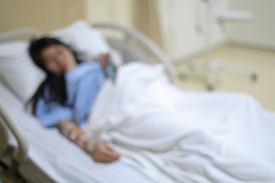 image blur of woman patient resting on bed inside recovery room in hospital