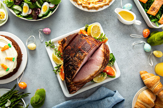 Big traditional Easter brunch with salmon, quiche lorraine and carrot cake and ham in the middle