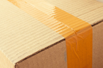 brown carton paper box package with packing scotch tape stick