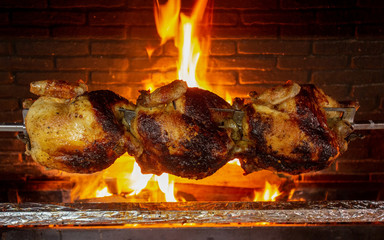 Fototapeta Roast chicken. Three chicken cooking with fire on the background. obraz