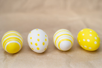 Easter eggs colored  yellow white decorated on crumpled craft paper background. Happy Easter card with copy space for text. Minimal eco easter style. Space for text