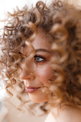 Fototapeta premium Large portrait of a happy cheerful beautiful cheerful cute bright curly teenage girl with clear skin and a beautiful smile, self-care self-love, beauty shooting