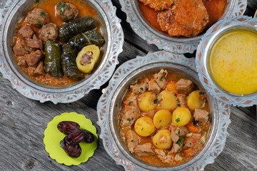 Eid Mubarak Traditional Ramadan Iftar dinner. Assorted tasty food in authentic rustic dishes on wooden table background.