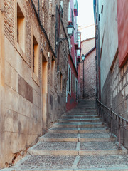 Old street of the city of Toledo with ascending stairs