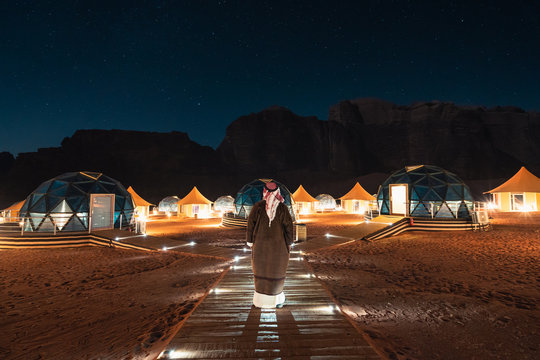 A Man Stading In Front Of Martian Dome Tents In Wadi Rum Desert, Jordan