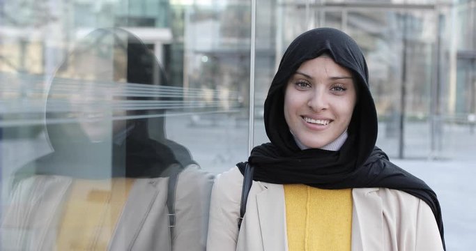 Attractive smiling woman wearing hijab and looking at camera