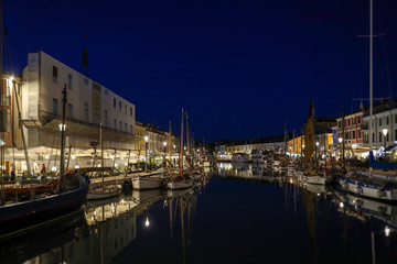 Fototapeta na wymiar Night view of the port canal designed by Leonardo da Vinci and old town of Cesenatico on the Adriatic sea coast