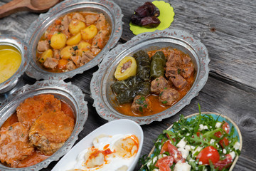 Eid Mubarak Traditional Ramadan Iftar dinner. Assorted tasty food in authentic rustic dishes on wooden table background.