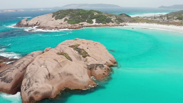 Circling point of interest aerial shot of the granite rocks around Twilight Cove and beach on an overcast day, Esperance, Western Australia
