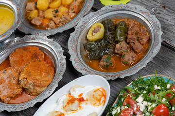 Eid Mubarak Traditional Ramadan Iftar dinner. Assorted tasty food in authentic rustic dishes on wooden table background.