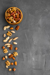Mixed nuts in bowl - healthy snack - on grey background top-down frame copy space