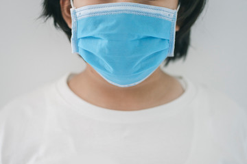 Young woman in protective medical mask quarantine herself at home to stop coronavirus or covid-19 pandemic.