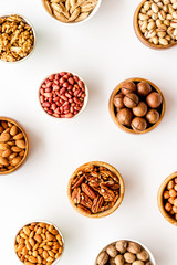 Set of macadamia, hazelnut, walnut, almond, pistachio, pecans nuts on white background top-down pattern
