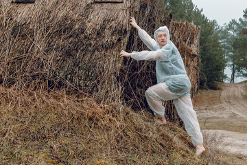 A man in a white protective overalls against the background of an old house. Protective suit...