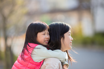 Fototapeta premium 春の公園で遊んでいる可愛い子供姉妹
