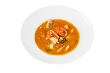 Fish soup in a bowl on white isolated background. Top view, close-up