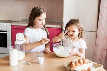 Obraz na płótnie Canvas Sisters prepare Breakfast, pastries, mix flour, milk, eggs, pancakes in a bowl, children help mother, family Breakfast, cooking