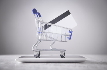 Shopping cart with credit card and tablet.