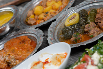 Eid Mubarak Traditional Ramadan Iftar dinner. Assorted tasty food in authentic rustic dishes on wooden table background.