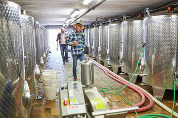 Winemakers in front of the fermentation tanks in the winery