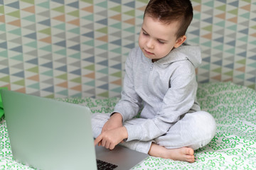 Fototapeta na wymiar Stay at home quarantine coronavirus pandemic prevention. A child learns online on a laptop during quarantine. Distance learning. Prevention epidemic. COVID-19.