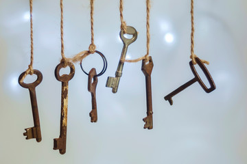 Old rusty keys hanged on the ropes with blurred soft background