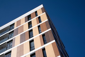 Exterior of new apartment buildings on a blue cloudy sky background. No people. Real estate business concept.