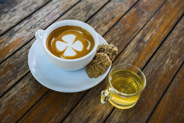 Cup of coffee on wooden table background.
