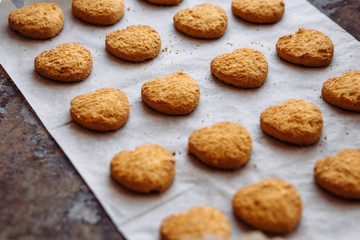 Freshly baked heart-shaped cookies on parchment paper