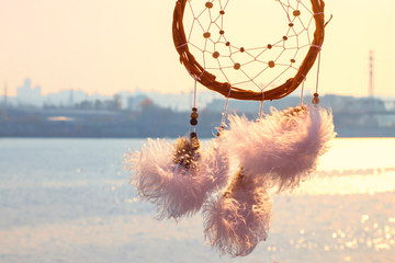 Dream catcher against the sky. City across the river. Far from the bustle of the city. Horizontal...