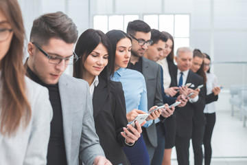 group of business people with smartphones standing in a row
