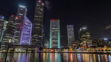 Fototapeta na wymiar Singapore quay with tall skyscrapers in the central business district on Boat Quay night timelapse hyperlapse
