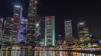 Singapore quay with tall skyscrapers in the central business district on Boat Quay night timelapse hyperlapse